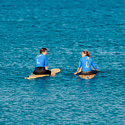 in attesa dell’onda perfetta surfisti seduti sulla tavola nel line-up mentre osservano le onde per scegliere quella giusta
