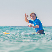 hang loose, amico! surfista sorridente che fa il gesto “hang loose” dopo una sessione di successo