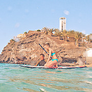 L'istruttore di SUP surf vi aiuta a salire sulla tavola