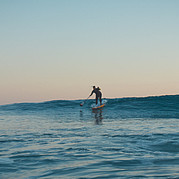 Pagaiare un'onda verde e pulita sulla tavola da SUP